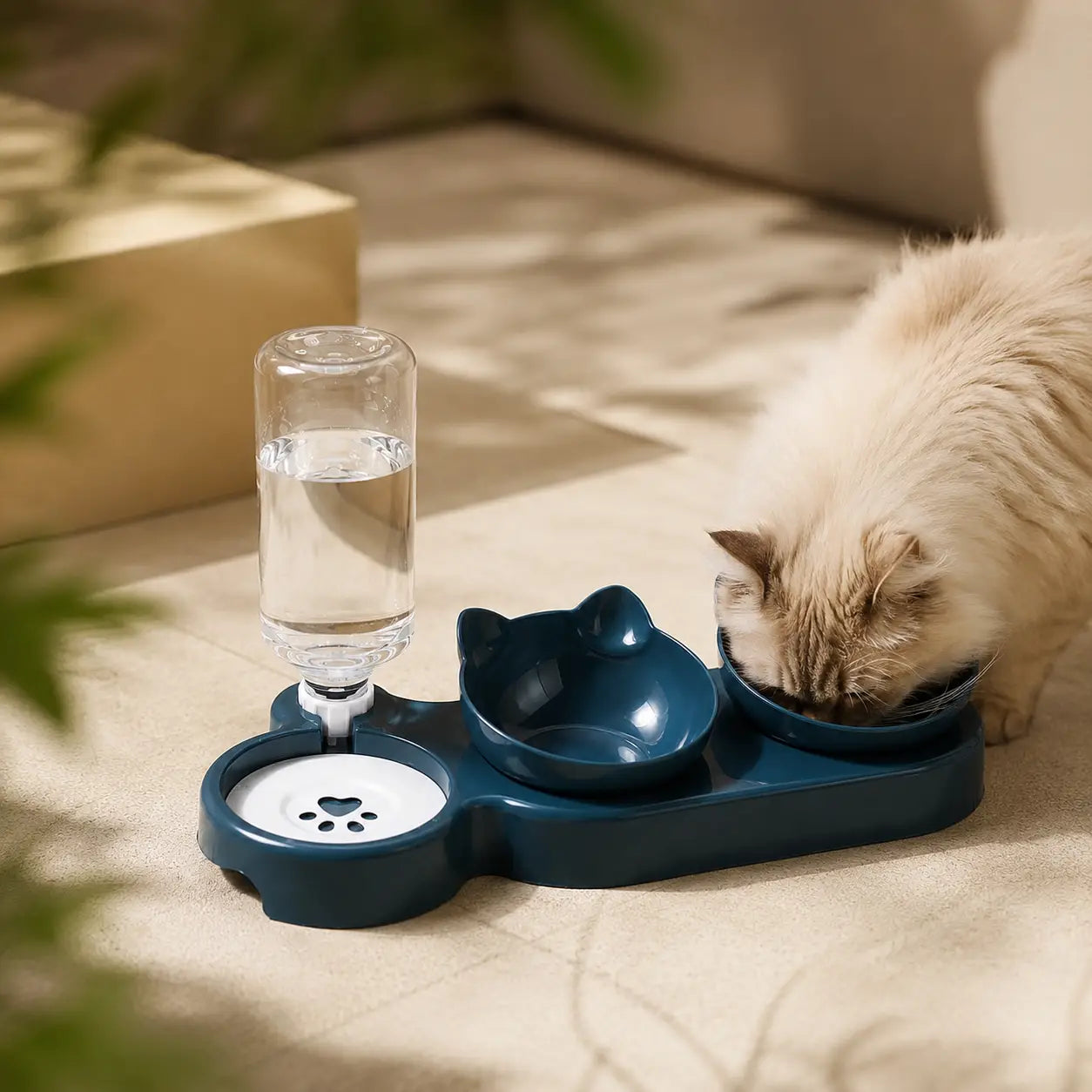 A fluffy cream-colored cat is shown drinking from a dark teal automatic pet water fountain with two bowls, set on a beige carpet in a home environment.