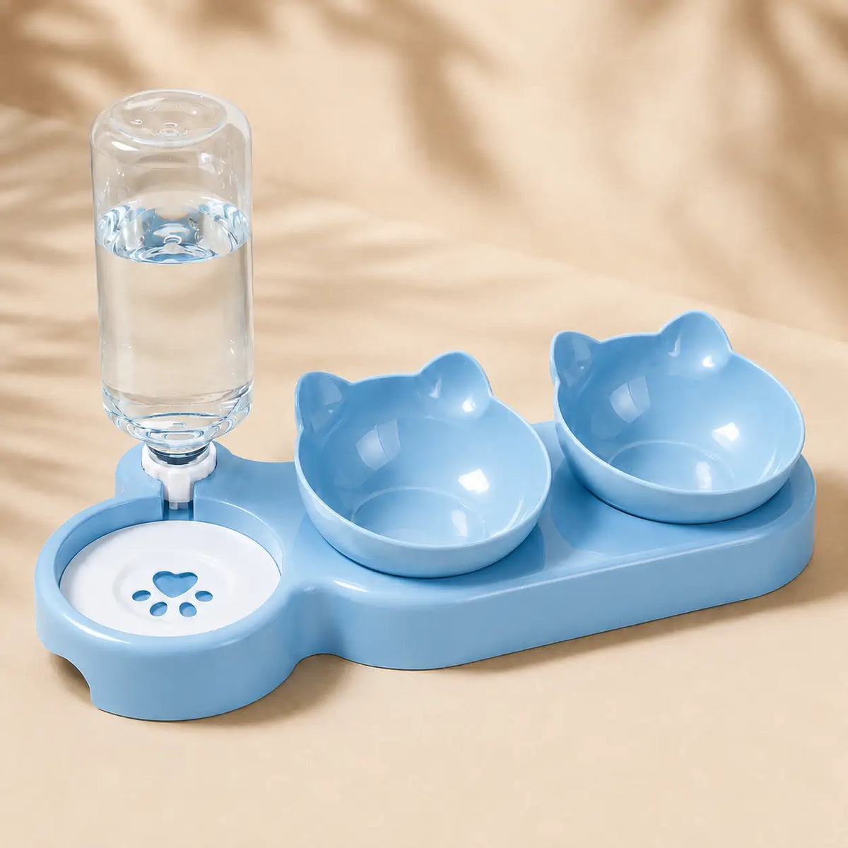 A light blue pet feeding station with two cat-shaped bowls, a water bottle holder, and a paw-print water dish, shown on a beige background.