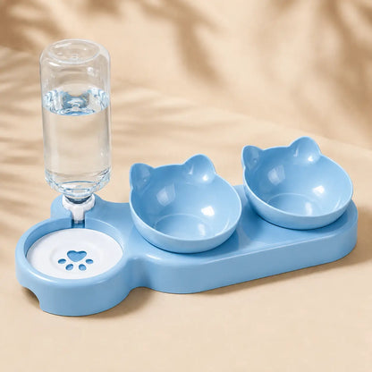 A light blue pet feeding station with two cat-shaped bowls, a water bottle holder, and a paw-print water dish, shown on a beige background.